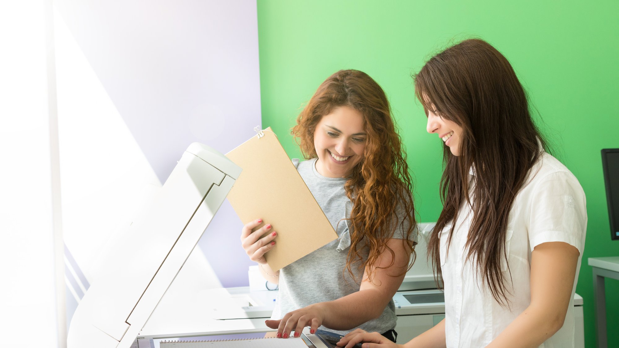 Two students at a copy center taking some copies for their final exams
