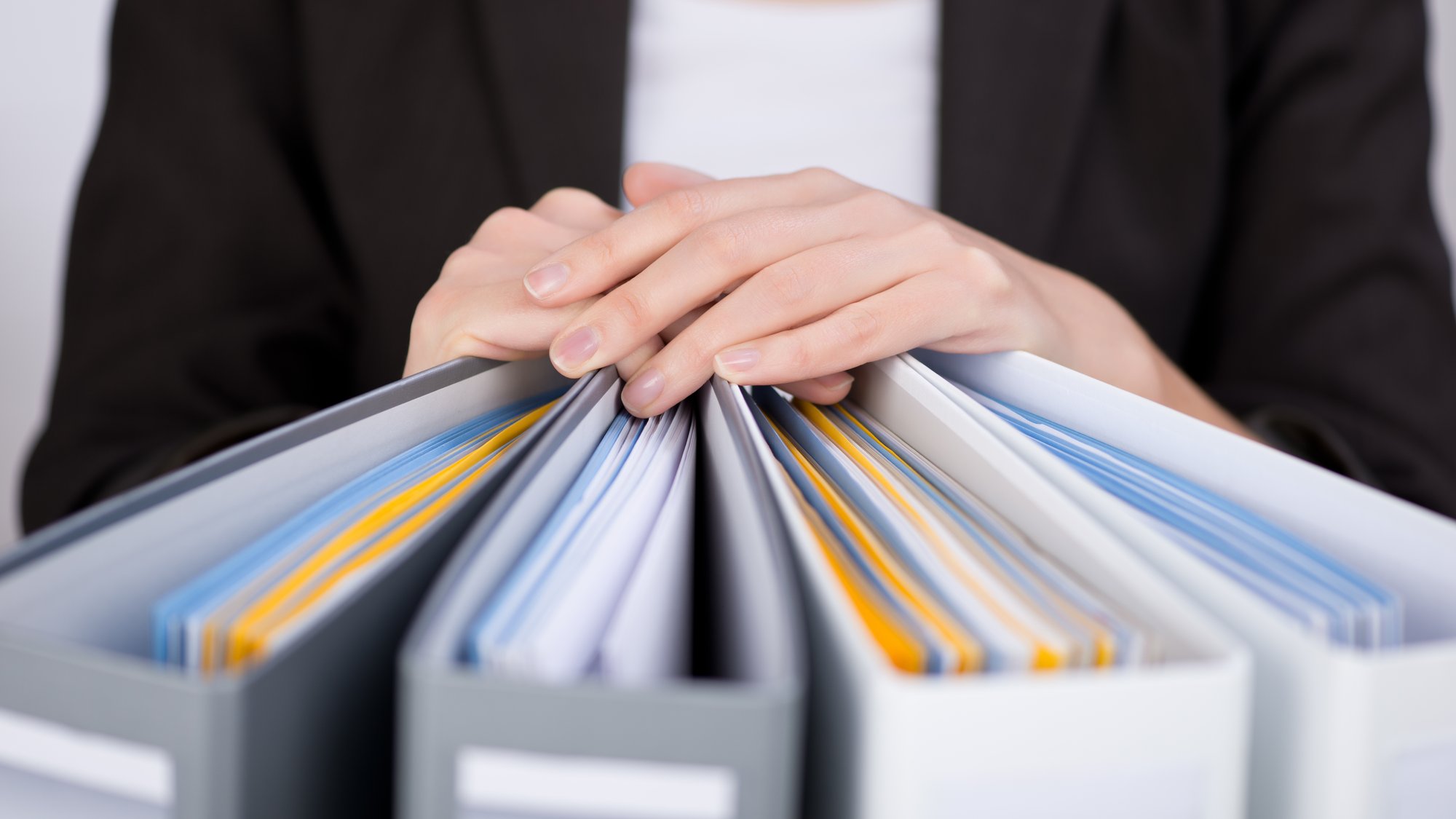 Midsection of businesswoman with binders at office