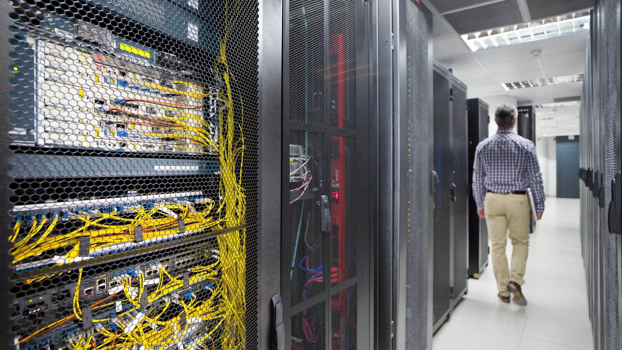 Technician With a Laptop walking out of the secured data center