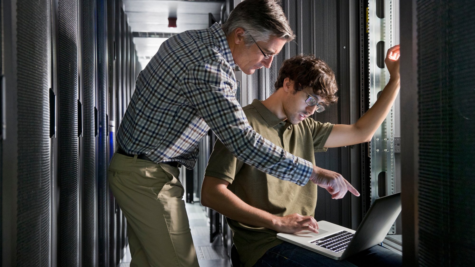 Two Technicians working on a laptop in the secured data center