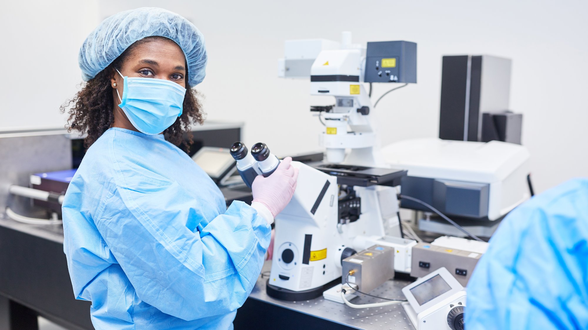 African woman as a researcher works on the microscope in a laboratory on Covid-19 vaccine for coronavirus pandemic