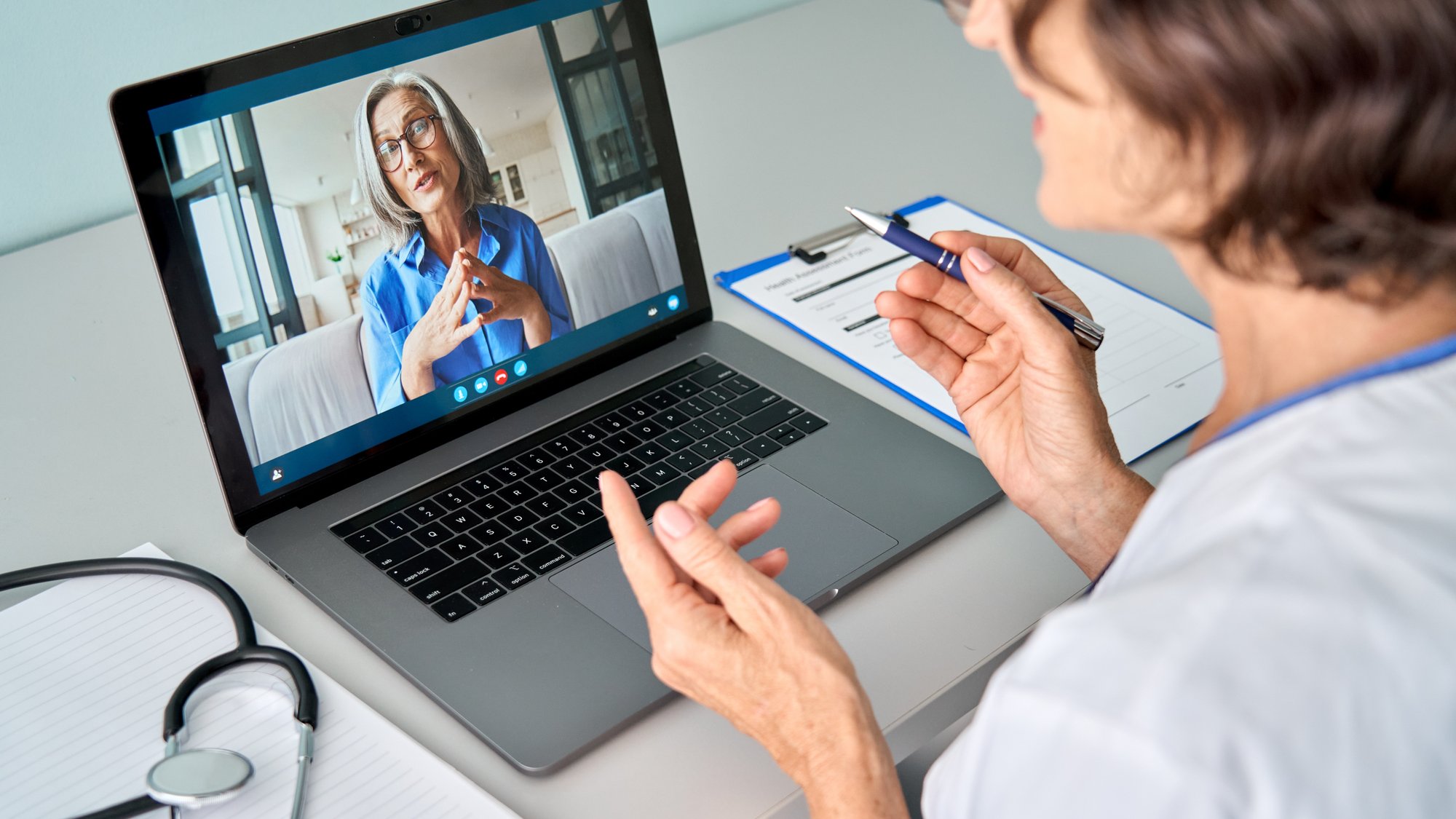Female doctor therapist consulting older senior patient via virtual video call visit using laptop computer. Digital online he
