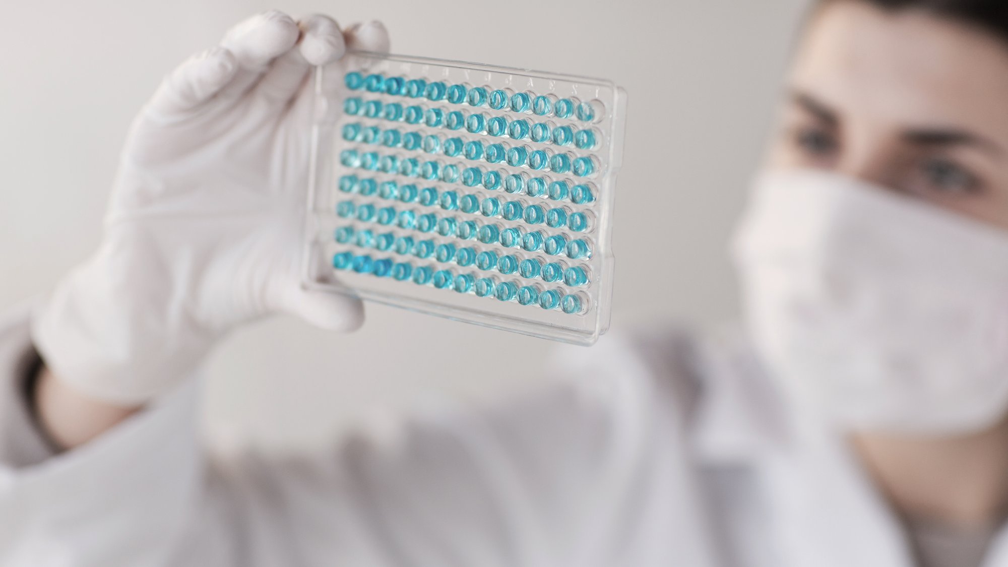 science, chemistry, biology, medicine and people concept - close up of young female scientist with pipette and flask making t